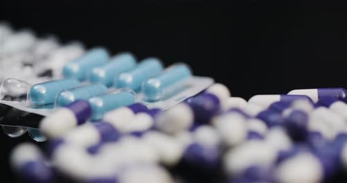 Colorful Pills and Capsules Close Up on Black