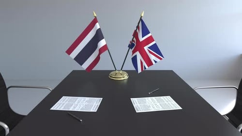 Flags of Thailand and the UK and Papers on the Table