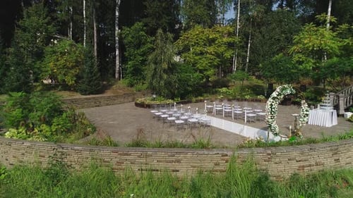 Outdoor Wedding Venue With Floral Arch and Chairs