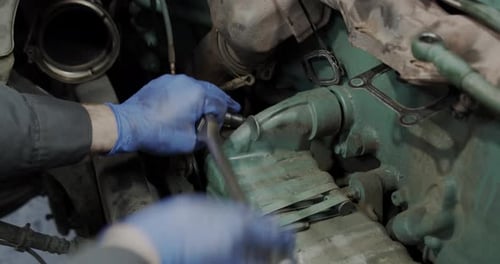 Mechanic Repairs Car Engine with Socket Wrench