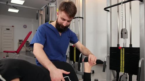 Physiotherapy Therapist Exercising Patient Working on Leg Stretching