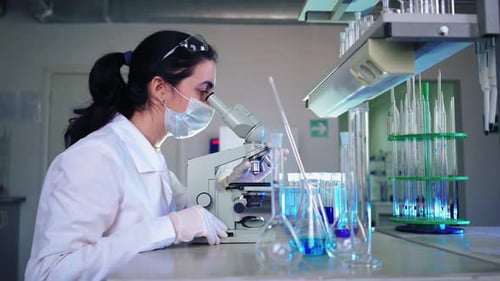 Mikrobiologin schaut ins Mikroskop im Labor für medizinische Wissenschaften