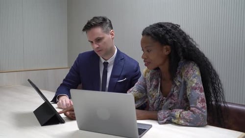 Business Professionals Collaborating on Tablet and Laptop