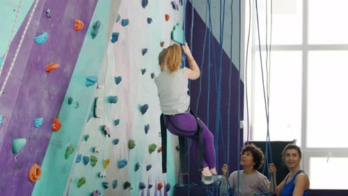 Little Girl Descends Climbing Wall with Assistance