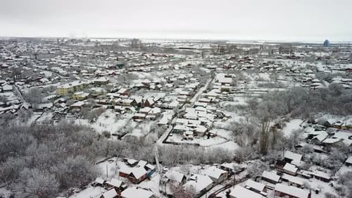 Blick auf eine kleine verschneite Stadt aus der Luft