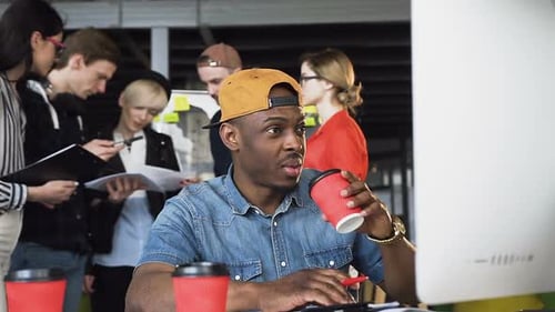 Homme afro-américain concentré en vêtements décontractés travaillant sur ordinateur