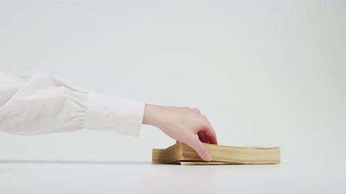 Hand Turning Pages of a Vintage Book