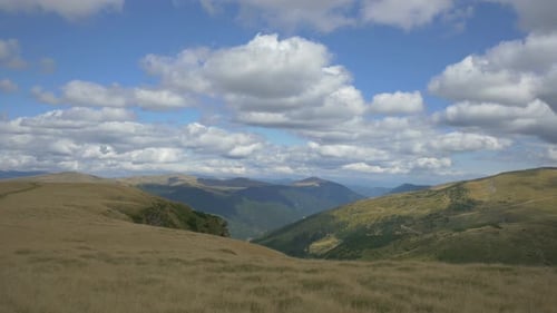 Mountain Vista with Rolling Hills and Cloudy Skies