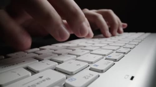 Zeitraffer-Typing in Nahaufnahme auf der Tastatur mit den Finger. Makro-Dolly-Shot mit weichem Fokus