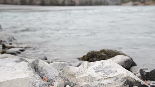 Dolly Slider Shot of the Splashing Water in a Mountain River Near Forest. Wet Rocks and Sun Rays