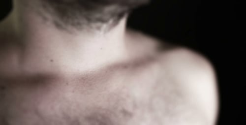 Male Neck and Upper Chest Against Black Background
