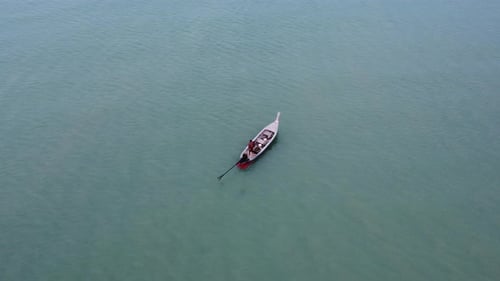Aerial view from a drone of Thai traditional longtail fishing boats sailing in the sea.