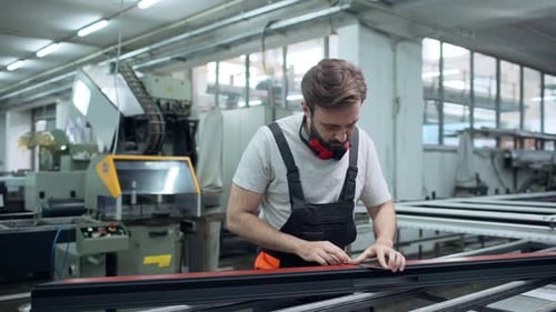 Porträt eines professionellen Arbeiters, Mann aus den 30er Jahren, der einen Overall trägt, mit Geräten arbeitet und misst