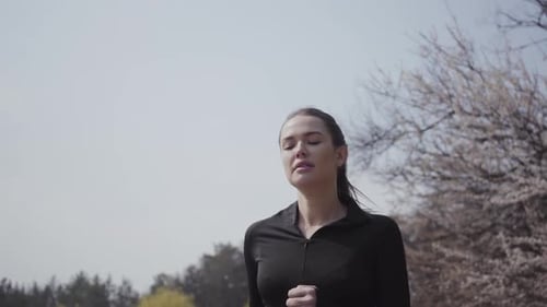 Woman Jogging in Park on Sunny Day