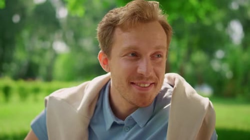 Smiling Man Relaxing in Park on Summer Day