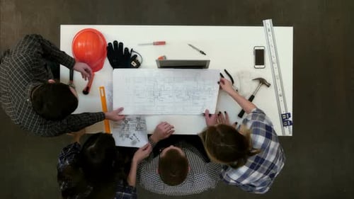 Gruppe junger Architekten, die an Zeichnungen arbeiten