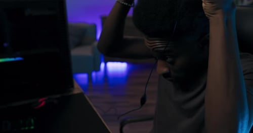 Young Adult Playing Video Game with Headphones