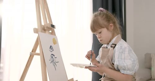 Child Painting a Picture on Easel Indoors