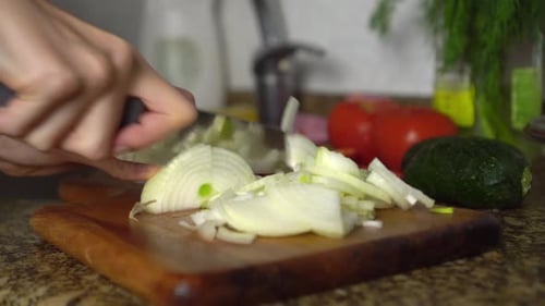 Hands Chopping an Onion in Kitchen