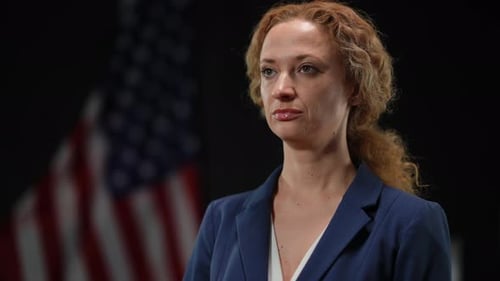 Professional Woman in Blue Suit Poses with Flag