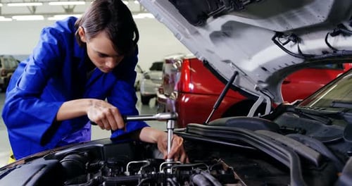 Female mechanic servicing a car
