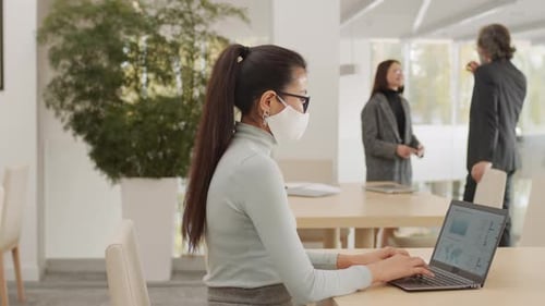 Woman Works on Laptop in Modern Office Space
