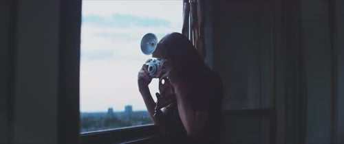 Woman with Camera Taking Pictures from Window