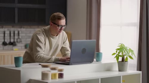 Man Working at Laptop in a Kitchen