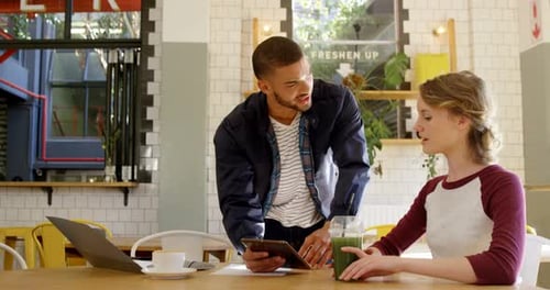 Executives discussing over a digital tablet in office cafeteria 4k