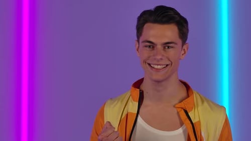 Young Man Smiling and Laughing in Front of Neon