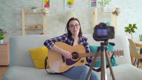 Woman Plays Guitar and Records Video at Home