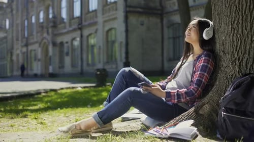 Student Listening to Music on Campus Lawn