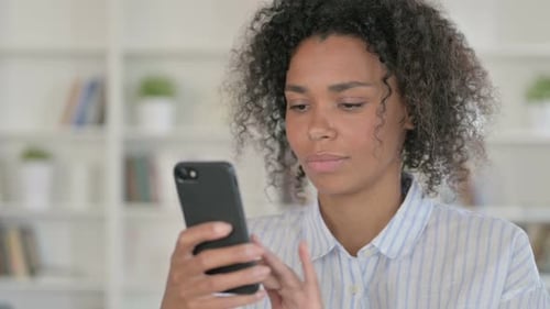 Young Woman Using Smartphone Indoors, Close Up