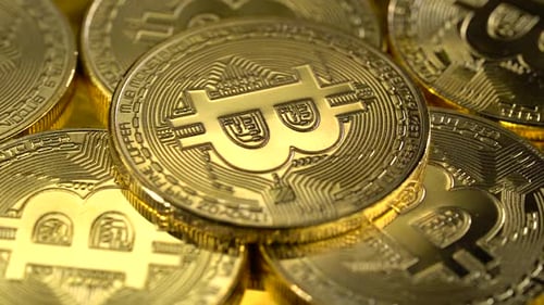 Die
physische Gold-Bitcoin-Münze dreht sich langsam. Makro-Shot