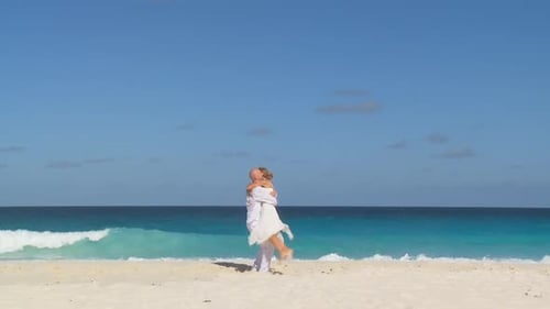 Couple Runs and Embraces on Beautiful White Beach