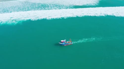 Fischerboot schwimmt auf Meereswellen in Ufernähe