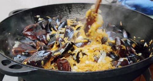 Slow Motion, Chef Cooking Kneads Paella with Shrimp, Mussel, Rice, Spice, Saffron in Huge Paella Pan