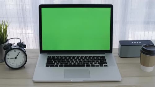 Slide shot, Chroma key green screen of laptop computer set on working space in home office.
