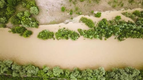 Aerial view of wide dirty river with muddy water in flooding period during heavy rains in spring.