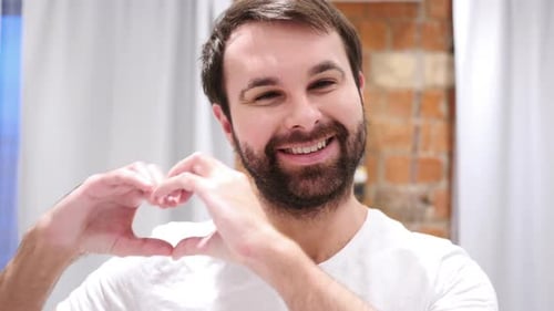Bearded Adult Man Makes Heart Symbol With Hands