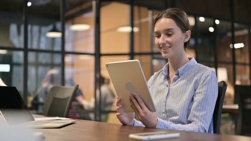 Young Woman Video Calling on Tablet in Office