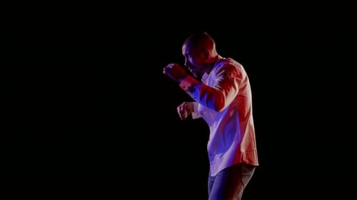 Man Practicing Boxing Punches Against Black Background