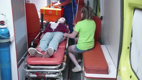 Verletzte Frau liegt auf einer Trage im Krankenwagen.