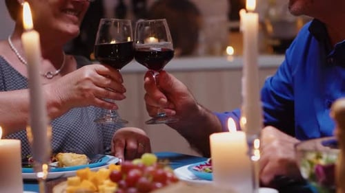 Mature Couple Celebrating Anniversary by Candlelight With Wine