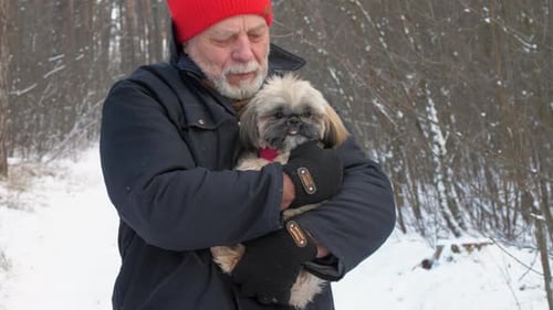 Old Man with Beard Holds Furry Trembling Dog in Arms