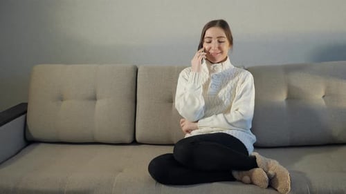Woman Chatting on Smartphone While Sitting on Couch