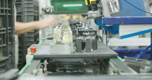 Ouvrier dans une chaîne de production de pièces pour l'industrie automobile
