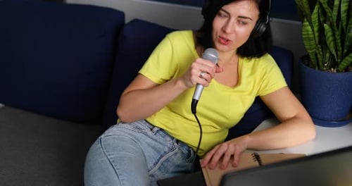 Woman Speaking Into Microphone at Home