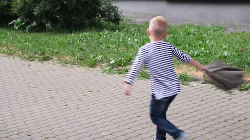 Back to School Children Playing on Street Blonde Boy and Girl Spinning with Backpacks