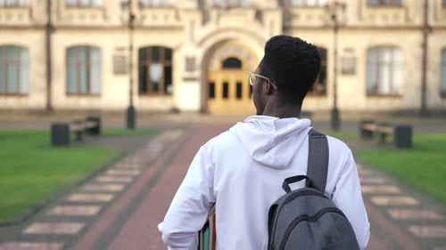 Back View Confident Young Student Walking to University Campus in Slow Motion Outdoors
